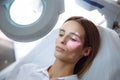 Close-up beautiful female face with vein scanner and cosmetologist`s hands with syringe during facial beauty injections Royalty Free Stock Photo