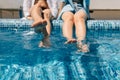 close-up of beautiful female legs in the swimming pool. Girlfriends girls swing their feet on the water in the pool. The