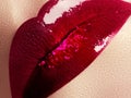 Close-up of beautiful full woman's lips with bright fashion gloss pink makeup. Macro shot with magenta lip