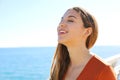 Close up of beautiful girl breathing and smiling with the sea and blue sky in the background Royalty Free Stock Photo