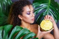 Close-up of beautiful girl with pineapple posing in tropical forest Royalty Free Stock Photo
