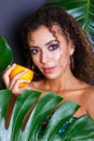 Close-up of beautiful girl posing in tropical forest. Portrait of beautiful African American woman with tropical fruits Royalty Free Stock Photo