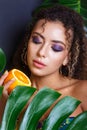 Close-up of beautiful girl posing in tropical forest. Portrait of beautiful African American woman with tropical fruits Royalty Free Stock Photo