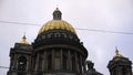 Close-up of the beautiful golden domes of Saint Isaac's Cathedral against the grey cloudy sky in Saint Petersburg Royalty Free Stock Photo