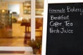 Close up beautiful hand writing menu on blackboard.Black chalk board in front of a coffee shop entrance.Blurred bakery and cafe ba Royalty Free Stock Photo