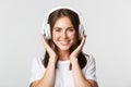 Close-up of beautiful happy girl smiling, enjoying listening music in wireless headphones Royalty Free Stock Photo
