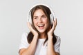 Close-up of beautiful happy girl smiling, enjoying listening music in wireless headphones Royalty Free Stock Photo