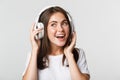 Close-up of beautiful happy girl smiling, enjoying listening music in wireless headphones Royalty Free Stock Photo