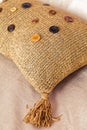 Close up beautiful knitted pillow with hand-made buttons. Shallow depth of field Royalty Free Stock Photo