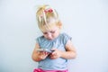Close up Beautiful little baby girl holding and playing with smart phone on the white wall background. Children and technology con Royalty Free Stock Photo