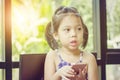 Close up of beautiful little cute girl looking up thinking and holding smartphone, Happy kid concept Royalty Free Stock Photo