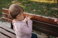 Close up of beautiful little smiled girl. Happy baby girl in autumn park. Ten month baby smile