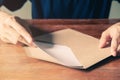 Close-up of Beautiful man hands opening envelope on the brown wooden tabel background Royalty Free Stock Photo