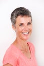 Close up beautiful middle age woman smiling by white wall Royalty Free Stock Photo