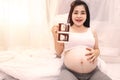 Close-up of a beautiful pregnant woman holding an ultrasound scan. A pregnant Asian woman is smiling holding an ultrasound image Royalty Free Stock Photo