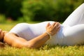 Close-up of beautiful pregnant woman in white clothes laying on grass Royalty Free Stock Photo