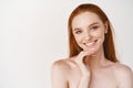 Close-up of beautiful redhead woman with pale skin, standing nude on white background, smiling with perfect teeth Royalty Free Stock Photo