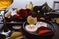 Close-up of a beautiful romantic dinner with champagne glass bubbles, flowers petals, roses, candles. Valentine`s day Royalty Free Stock Photo