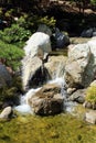 Close up of a beautiful stream with small rocky waterfalls in The Friendship Garden in Balboa Park in San Diego