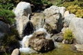 Close up of a beautiful stream with small rocky waterfalls in The Friendship Garden in Balboa Park in San Diego