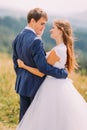 Close-up of beautiful stylish dressed pair holding each other outdoors at sunny day