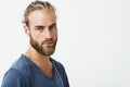 Close up of beautiful swedish man with stylish hairstyle and beard in blue t-shirt looking in camera with serious Royalty Free Stock Photo