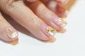 Close up beautiful Trendy crack shell decorated on woman short fingernail with sparkling silver and gold glitter in clear gel nail