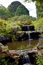 A close up of a beautiful waterfall that runs through a garden. Royalty Free Stock Photo