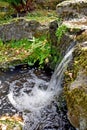 A close up of a beautiful waterful , the water creates a ripple effect as it splashes into the pond below. Royalty Free Stock Photo