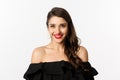 Close-up of beautiful woman dressed for party in black dress, wearing makeup and red lipstick, smiling happy at camera Royalty Free Stock Photo