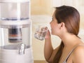 Close up of a beautiful woman drinking a glass of water with a filter system of water purifier on a kitchen background
