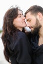 Close up beautiful woman hugging man in white monophonic background, wearing black shirt.