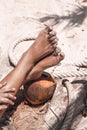 Close up of beautiful woman legs on wild beach with coconut Royalty Free Stock Photo