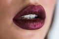 Closeup of beautiful woman lips with purple lipstick. Open mouth with white teeth. Cosmetics, lip gloss Royalty Free Stock Photo