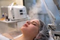 Close up of beautiful woman during ozone facial steamer face treatment in beauty clinic. Royalty Free Stock Photo