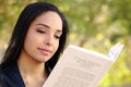 Close up of a beautiful woman reading a book in a park