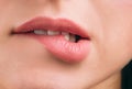 Close up of beautiful women`s lips covered with lipstick. Bite lower lip. White teeth. Sexy move. Cut view.