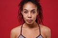 Close up of beautiful young african american sports fitness woman in sportswear posing working out isolated on red wall Royalty Free Stock Photo