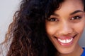 Close up beautiful young african american woman with curly hair smiling against gray backgorund Royalty Free Stock Photo