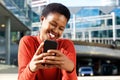 Close up beautiful young african american woman smiling and looking at cellphone Royalty Free Stock Photo