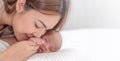 Close up beautiful young asian mother kissing her newborn one month baby sleep in bed. Healthcare and medical love asia woman Royalty Free Stock Photo