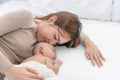 Close up beautiful young asian mother kissing her newborn one month baby sleep in bed. Healthcare and medical love asia woman Royalty Free Stock Photo