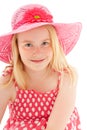 Close up of beautiful young blonde girl with enigmatic smile wearing a big pink floppy hat and looking directly at the camera. Royalty Free Stock Photo