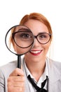 Young businesswoman smiling and looking through magnifying glass Royalty Free Stock Photo