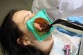 Close up of beautiful young female having dental check up in dental clinic.