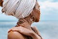 Close up of beautiful young tribal woman in turban at blue sea and sky background