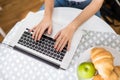 Close up Beautiful young woman with coffee using typing laptop in the kitchen in the morning Royalty Free Stock Photo