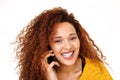 Close up beautiful young woman with curly hair talking on mobile phone against isolated white background Royalty Free Stock Photo