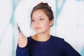 Close up of beautiful young woman holding a eyeliner in her hand, in a blurred background Royalty Free Stock Photo