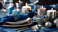 Close up of a beautifully decorated Hanukkah table featuring elegant blue and silver elements, candles, and decorative items Royalty Free Stock Photo